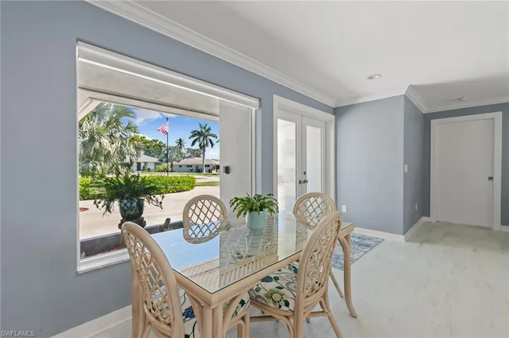 Dining room featuring light wood-style flooring, baseboards, and ornamental molding