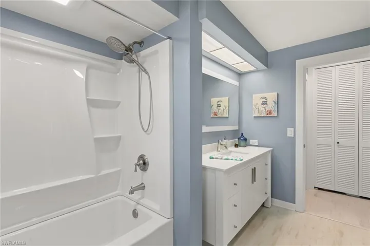Full bathroom featuring wood finished floors, shower / washtub combination, a closet, baseboards, and vanity