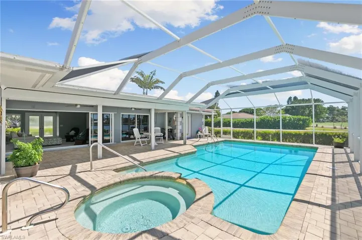 View of pool featuring a ceiling fan, a lanai, a patio area, and a pool with connected hot tub