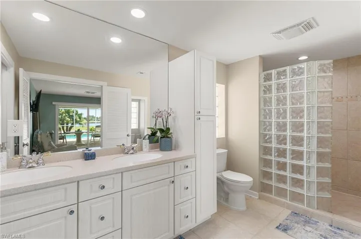 Bathroom with tile patterned floors, toilet, visible vents, and a sink