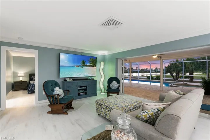Living area featuring visible vents, crown molding, and wood finished floors