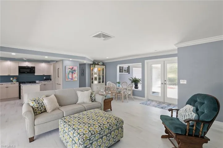 Living room with visible vents, light wood-style flooring, recessed lighting, french doors, and baseboards