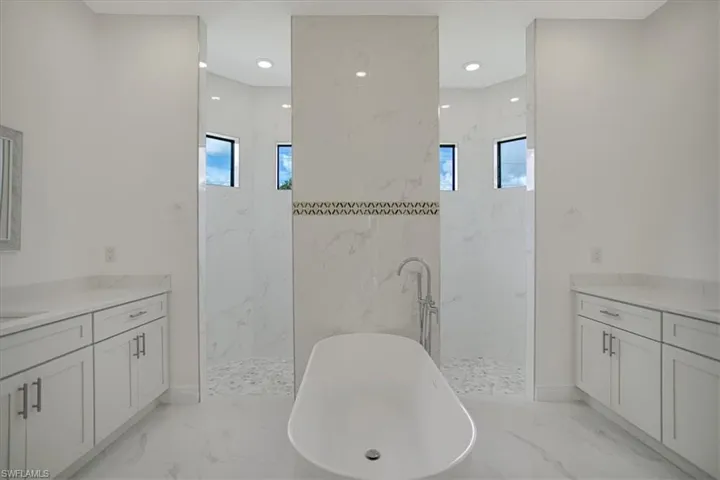 Bathroom featuring vanity, tile floors, and plus walk in shower