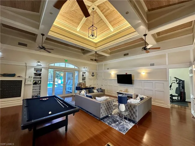 Recreation room featuring coffered ceiling, french doors, ornamental molding, a decorative wall, and billiards