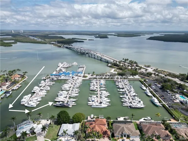Aerial perspective showcasing waterfront properties alongside a marina with numerous boats