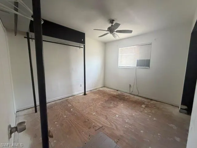 Interior room featuring a ceiling fan, window with blinds, and white painted walls