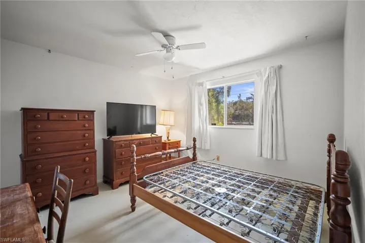 Bedroom with light carpet and a ceiling fan