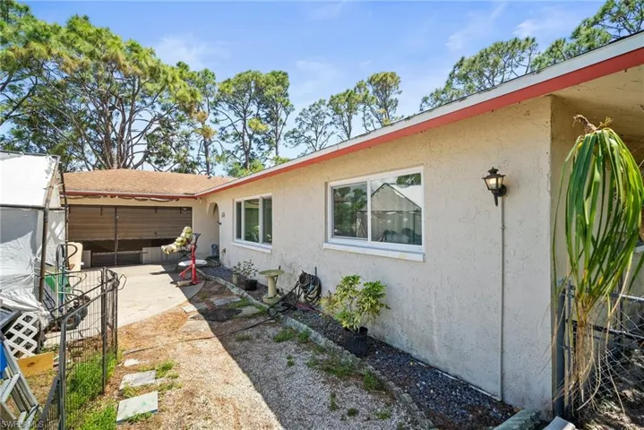 View of side of property with stucco siding and a patio