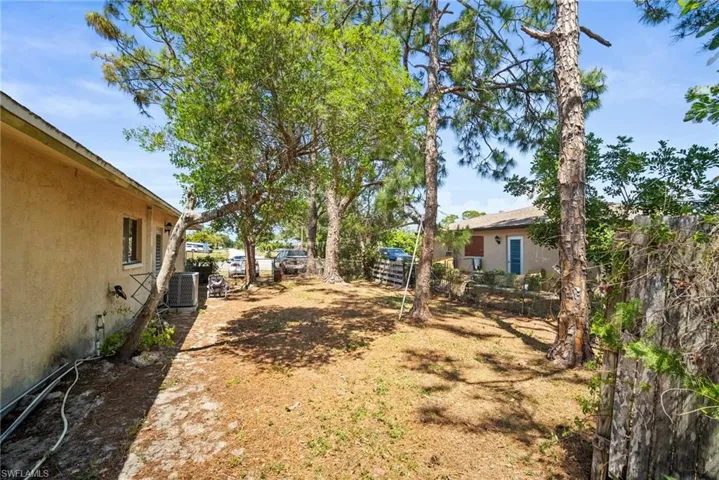 View of yard featuring central AC unit and fence