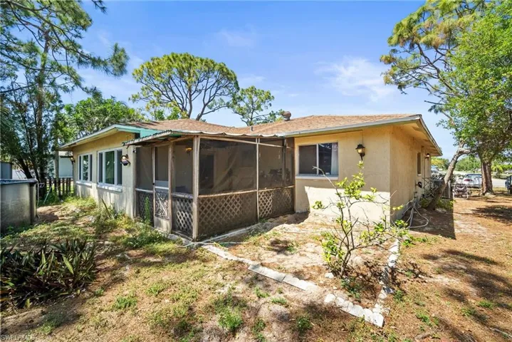 Back of house featuring stucco siding and a sunroom