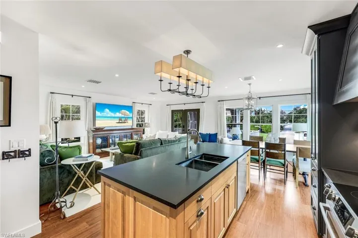 Kitchen featuring dark countertops, visible vents, light wood-style flooring, stainless steel appliances, and a sink
