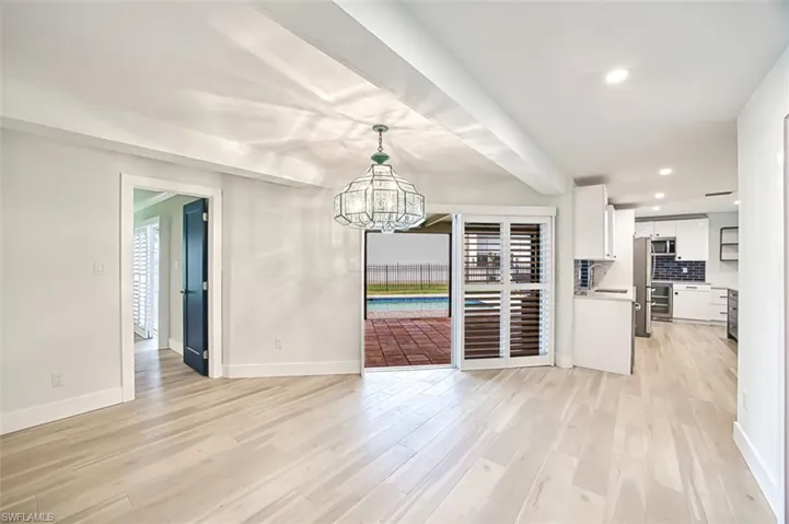 Unfurnished dining area with a chandelier, recessed lighting, light wood-type flooring, and a healthy amount of sunlight