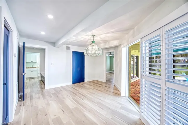 Unfurnished dining area with a chandelier, light wood-type flooring, visible vents, and baseboards