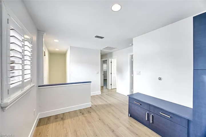 Spare room with light wood-type flooring, visible vents, and baseboards