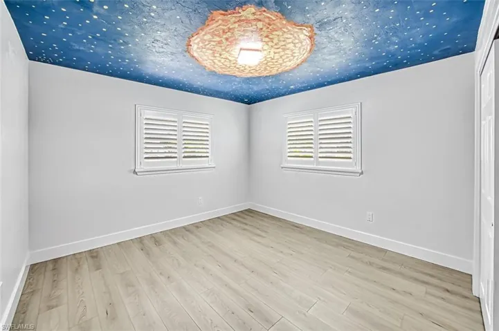 Unfurnished room with baseboards and wood finished floors