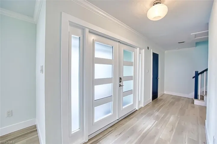 Doorway to outside with light wood finished floors, french doors, baseboards, and crown molding