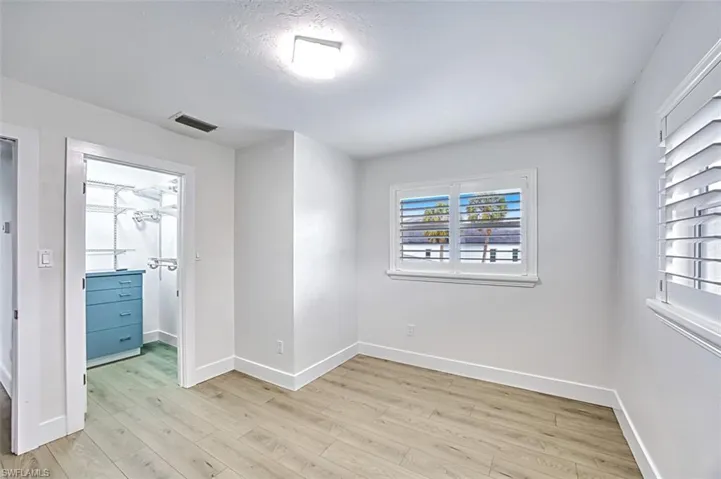 Spare room featuring light wood-type flooring, visible vents, and baseboards