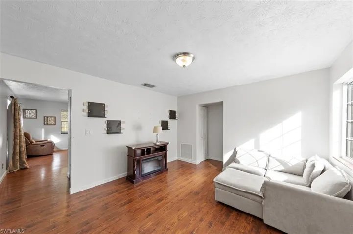 Living area featuring wood-finish flooring, neutral wall paint, and a ceiling-mounted light fixture