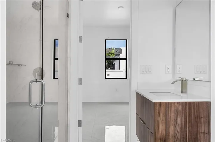 Bathroom with walk in shower, dual vanity, and tile patterned floors