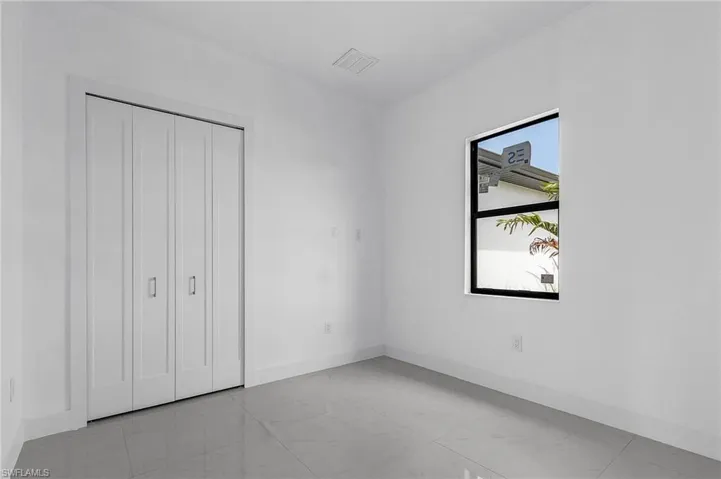 Unfurnished bedroom with multiple windows and light tile patterned floors