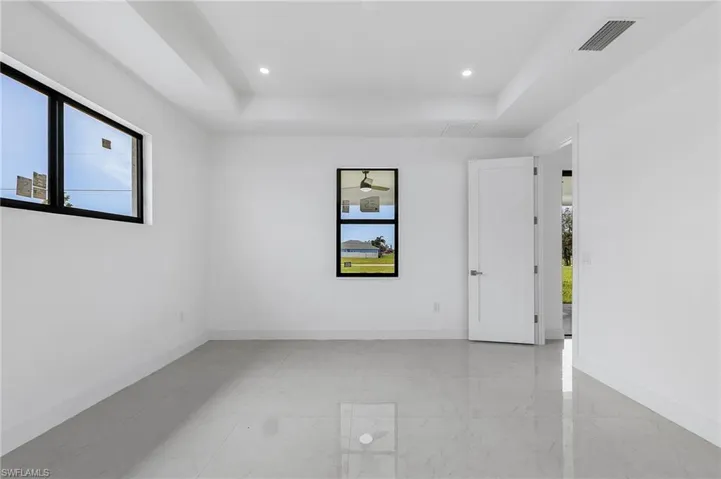 Spare room featuring light tile patterned flooring and a raised ceiling