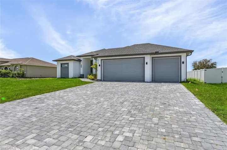 View of front of house with a garage and a front lawn