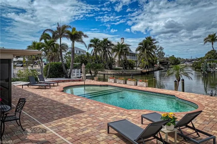View of pool featuring a water view, a patio, a hot tub, and a fenced in pool