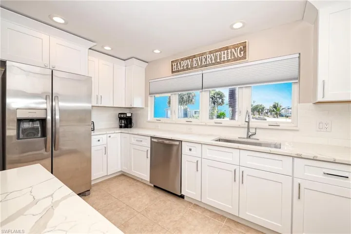 Kitchen featuring white cabinetry, a sink, light tile patterned floors, and appliances with stainless steel finishes