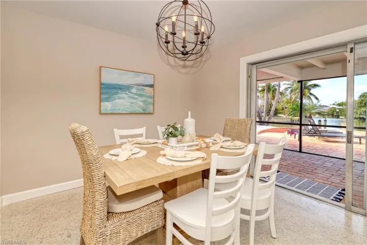 Dining room featuring baseboards, a notable chandelier, and speckled floor