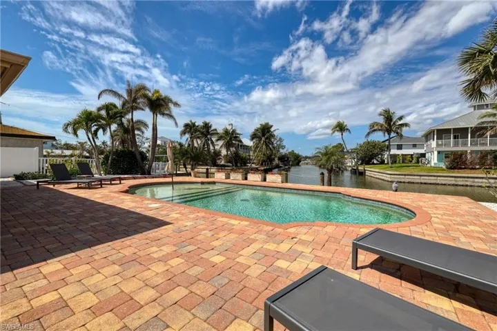 Pool featuring a patio and a water view