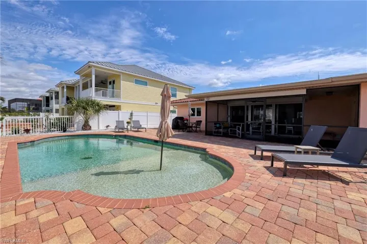 View of swimming pool featuring a fenced in pool, a sunroom, fence, and a patio area
