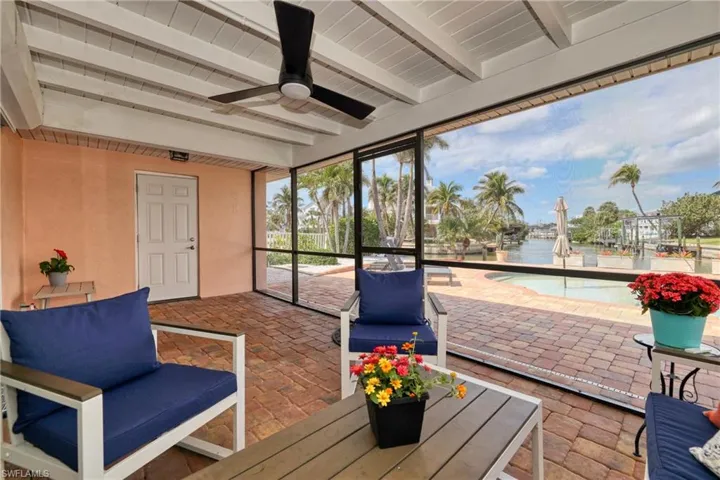 Sunroom featuring beam ceiling and a water view