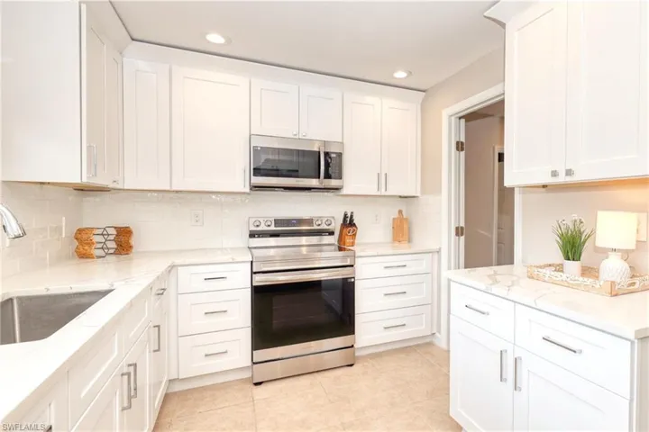 Kitchen featuring white cabinetry, a sink, and appliances with stainless steel finishes