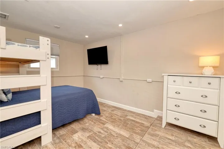 Bedroom with baseboards, visible vents, wood tiled floor, and recessed lighting