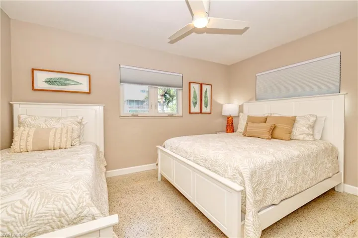 Bedroom with baseboards, light speckled floor, and ceiling fan