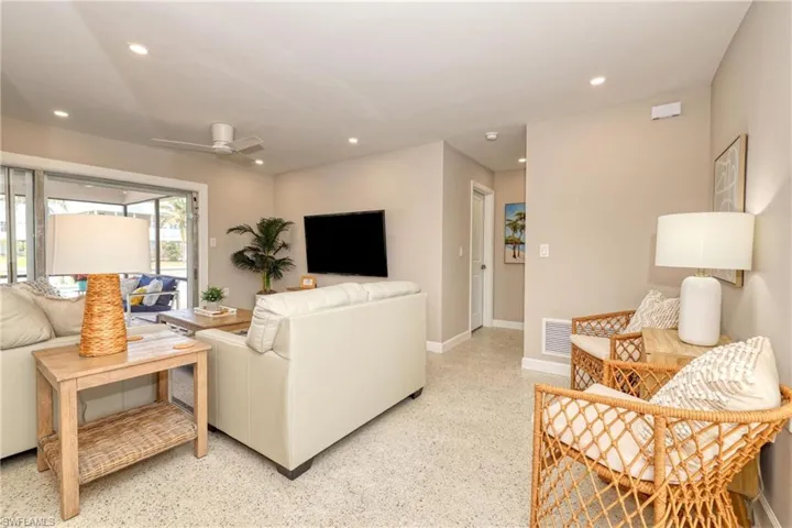 Living area with light speckled floor, baseboards, visible vents, ceiling fan, and recessed lighting