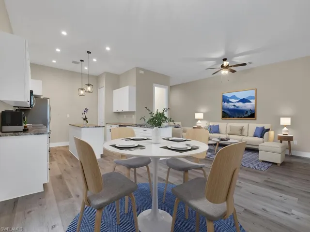 Dining area with ceiling fan, light wood-type flooring, and sink