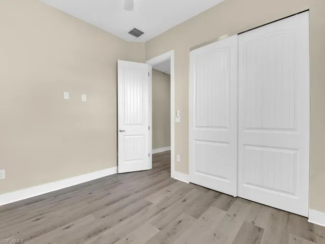 Unfurnished bedroom featuring ceiling fan, a closet, and hardwood / wood-style flooring