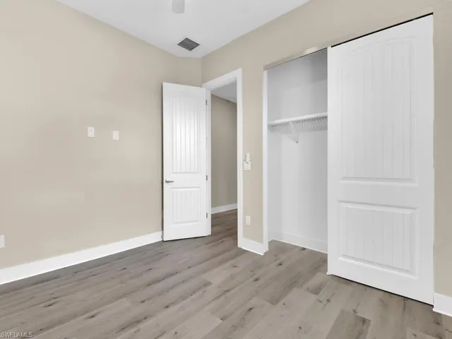 Unfurnished bedroom featuring ceiling fan, a closet, and hardwood / wood-style flooring