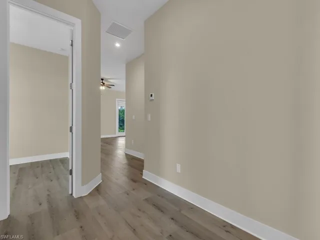 Hallway with hardwood / wood-style floors