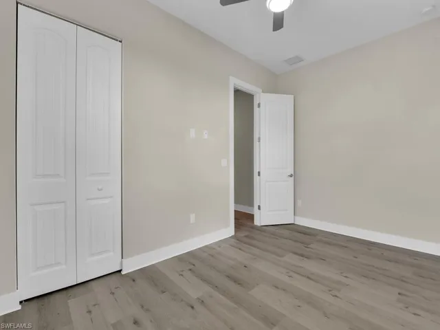 Unfurnished bedroom with hardwood / wood-style flooring, a closet, and ceiling fan