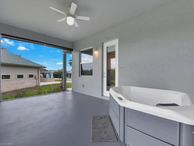 View of terrace featuring ceiling fan and a hot tub