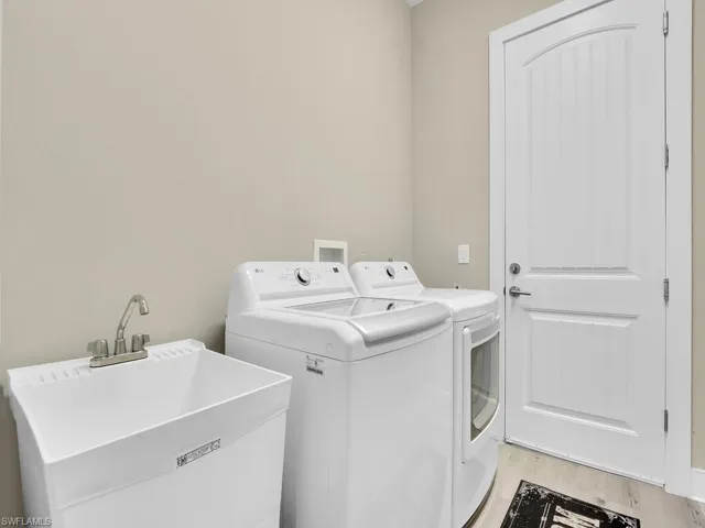 Laundry area featuring hookup for a washing machine, sink, light wood-type flooring, and washing machine and dryer