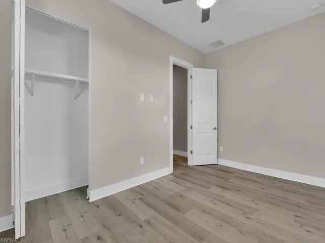 Unfurnished bedroom featuring ceiling fan, a closet, and hardwood / wood-style flooring