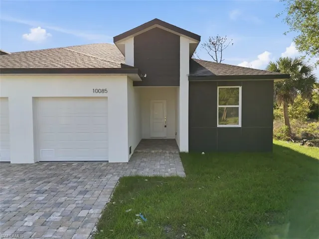View of front of property with roof with shingles, an attached garage, and stucco siding