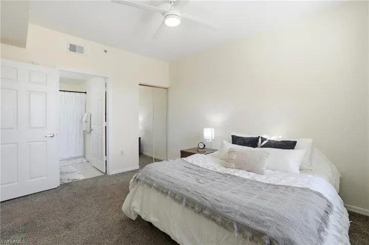 Carpeted bedroom with a closet and ceiling fan
