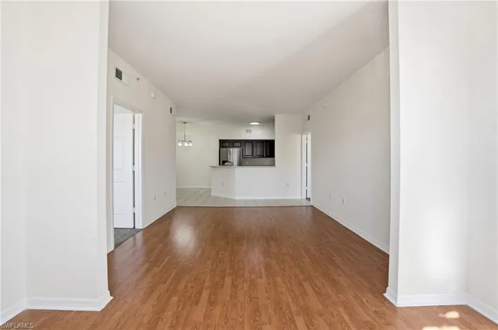 Unfurnished living room featuring light wood finished floors and a chandelier