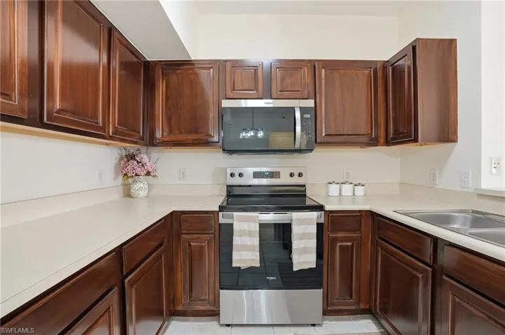 Kitchen featuring appliances with stainless steel finishes, light countertops, and light tile patterned flooring