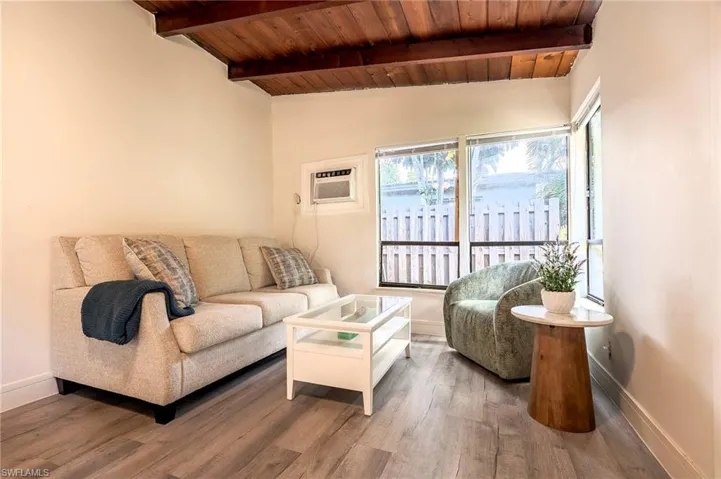 Living area featuring vaulted ceiling with beams, wood ceiling, and wood finished floors