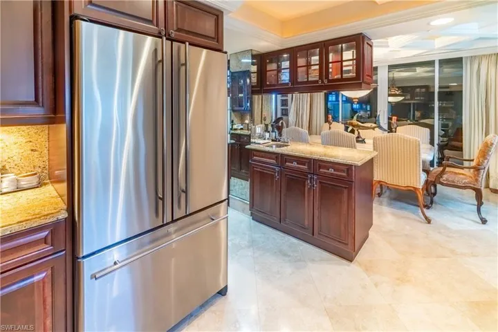 Stainless steel refrigerator integrated with dark wood-finish cabinetry